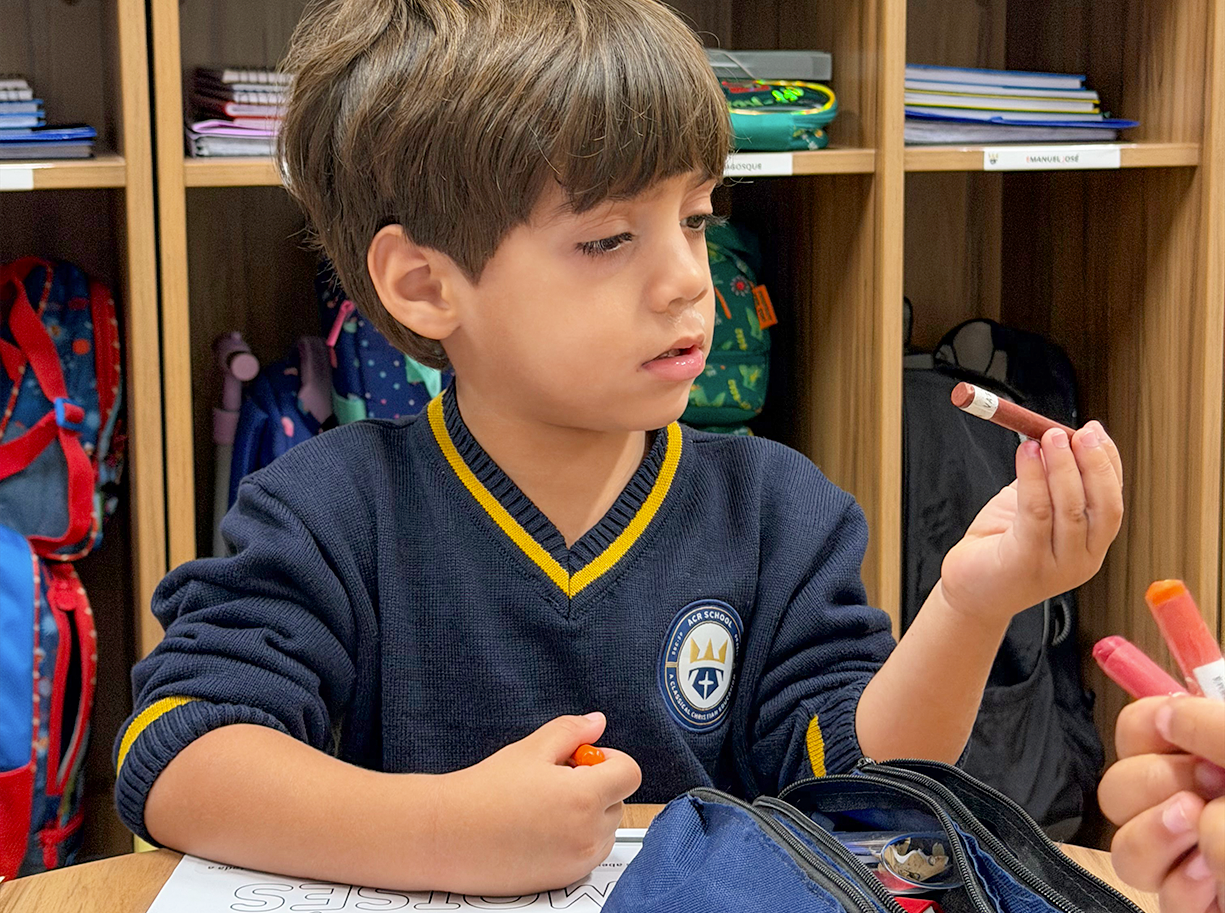Criança da Educação Infantil da ACR School desenhando